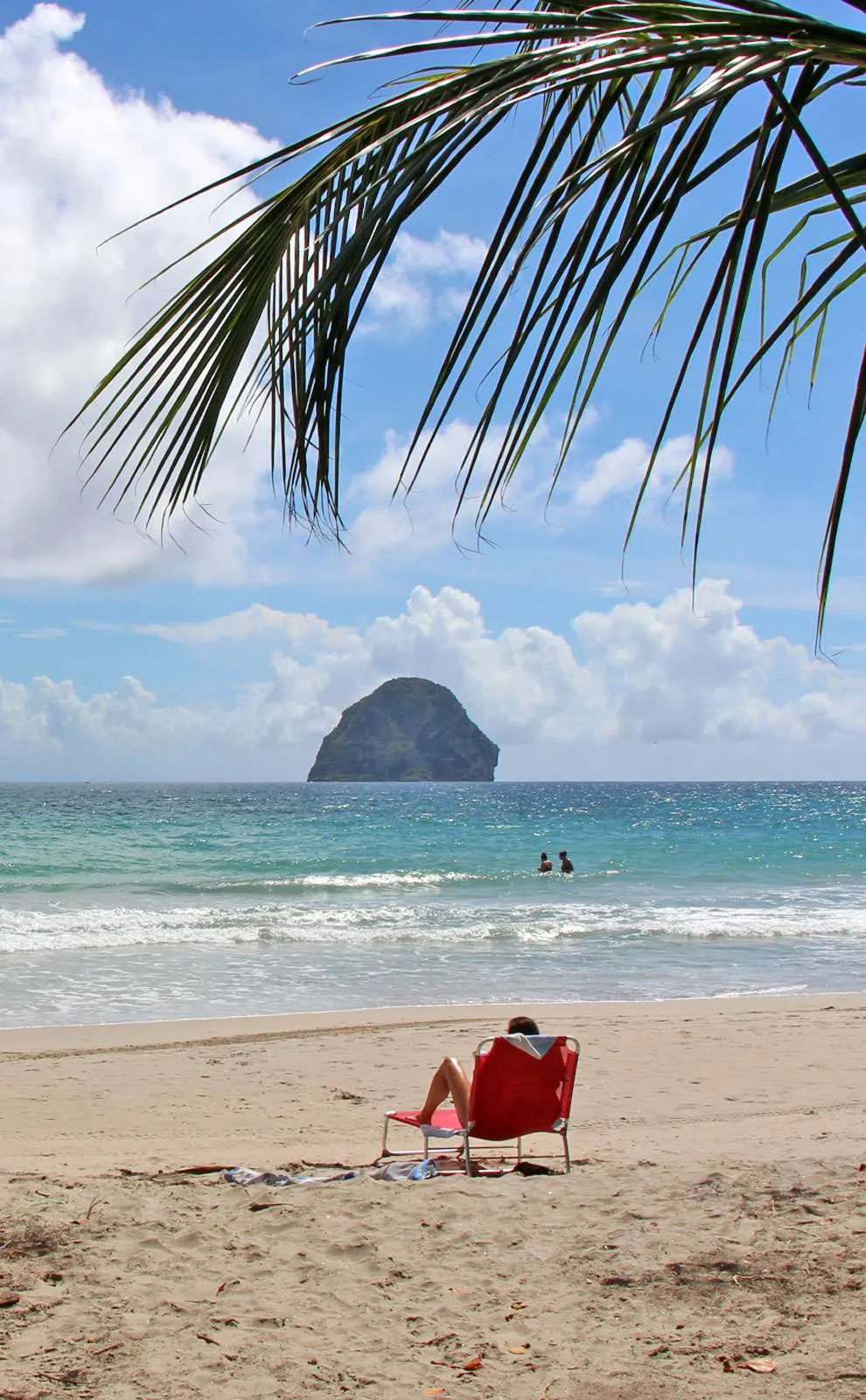 Personne sur une chaise rouge en face du Rocher du Diamant